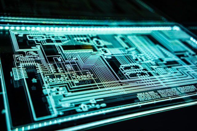 Carte électronique avec circuits lumineux turquoise, en gros plan